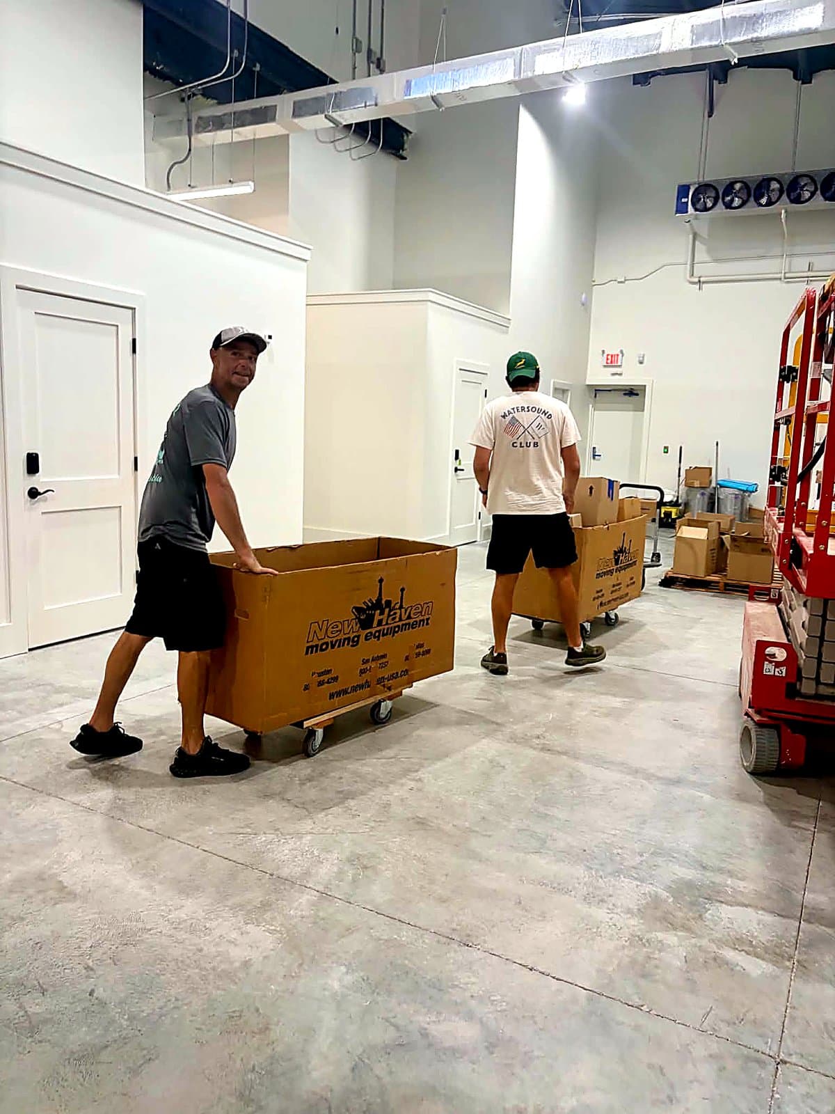 Beach House Moving crew rolling delivery carts through a new wine storage facility on 30A