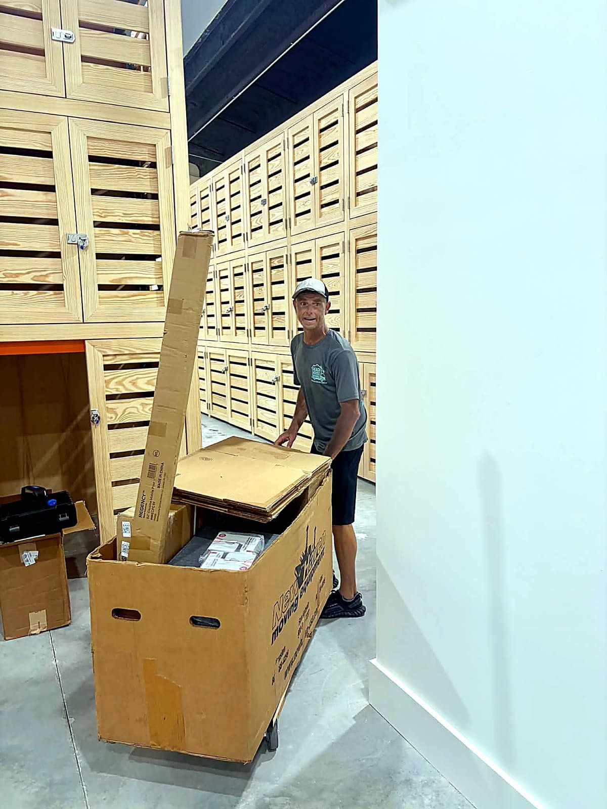 Beach House Moving crew unpacking a glassware delivery crate beside wine storage lockers
