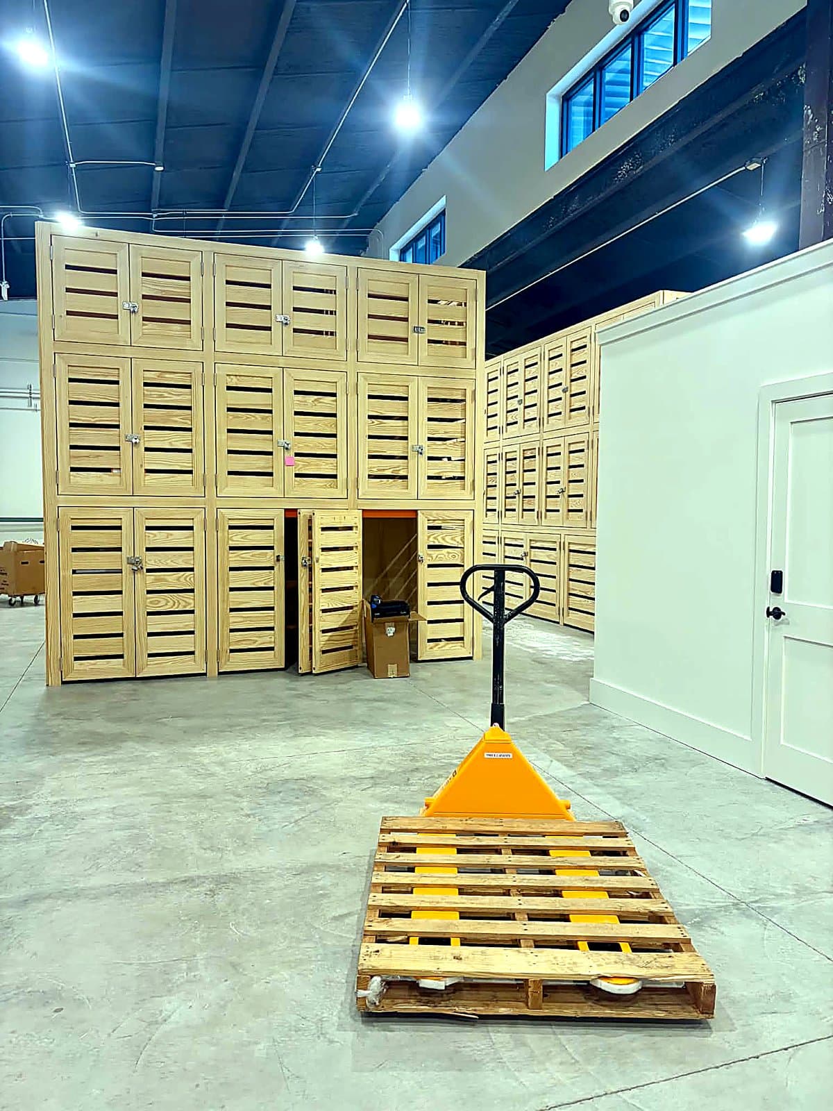 Pallet jack staged in front of custom wooden wine lockers at a new 30A storage facility
