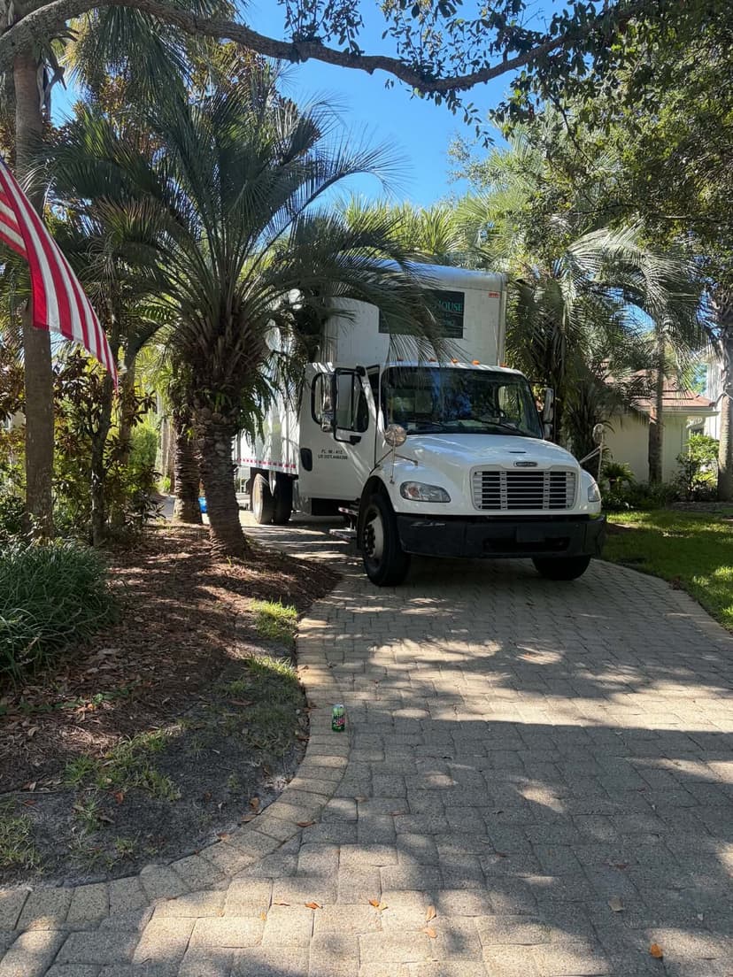 Beach House Moving box truck parked on a paver driveway at a Regatta Bay home in Destin, FL
