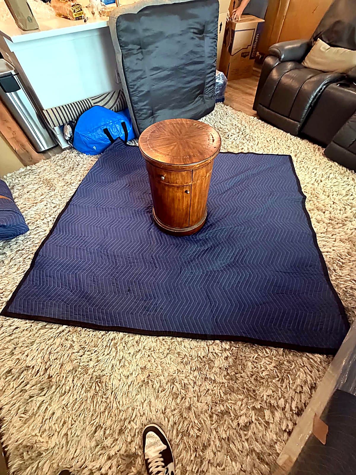 Antique drum side table staged on a moving blanket before pad-wrapping