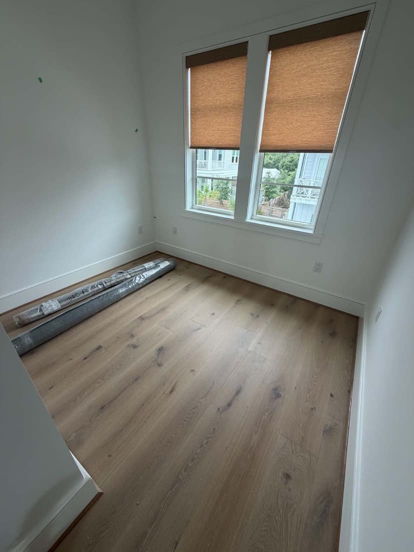 Wrapped rugs labeled by floor staged in an empty new-construction beach home on 30A by Beach House Moving