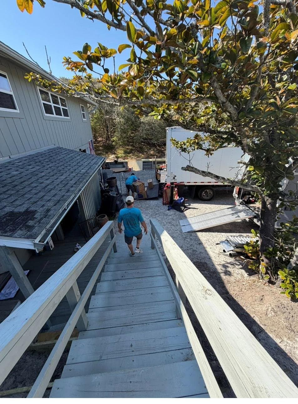 Beach House Moving crew carrying items down stairs to the truck