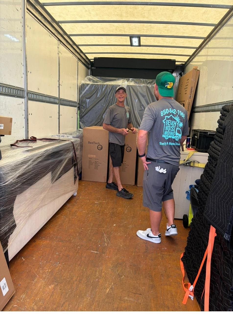 Movers loading furniture into a Beach House Moving truck