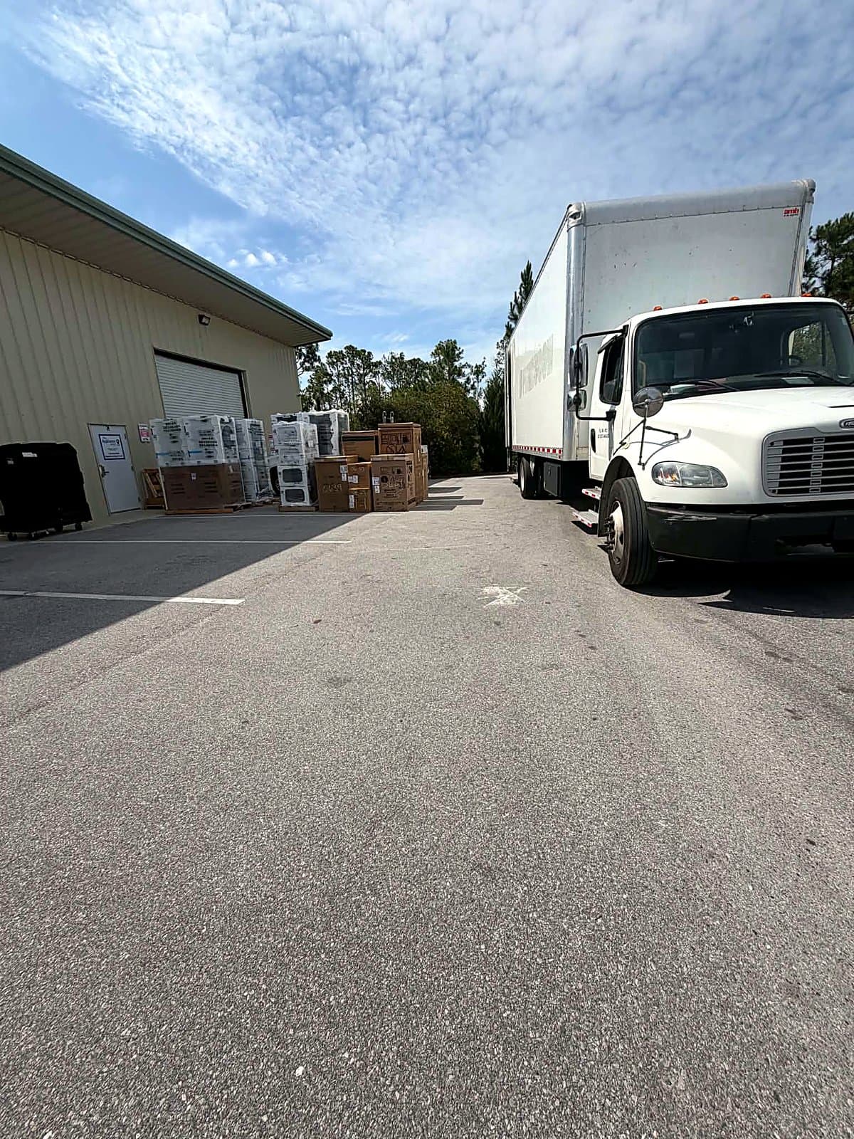 Beach House Moving box truck staged at a warehouse dock with packed inventory