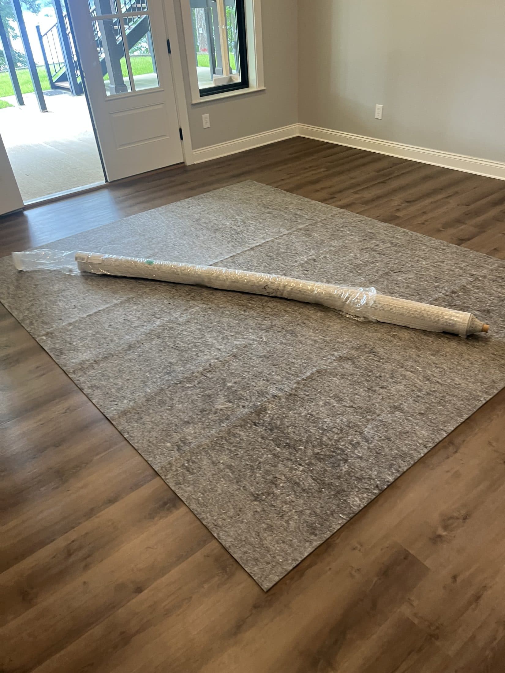 Beach House Moving installing a designer area rug in a new-construction entry