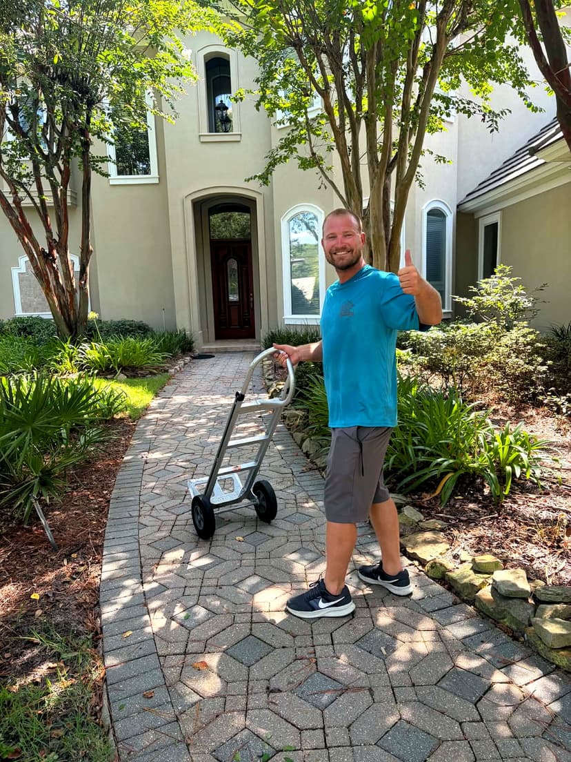 Beach House Moving mover Zack with a hand truck at the front walk of an Emerald Coast home before an estate sale prep move