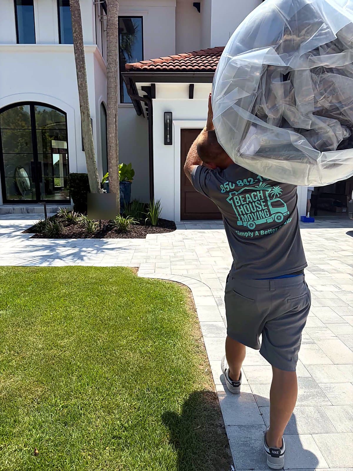 Beach House Moving crew delivering a protected chair to a new-construction home