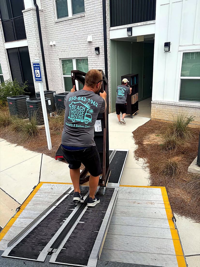 Beach House Moving crew unloading furniture down a lift-gate ramp at a Santa Rosa Beach apartment
